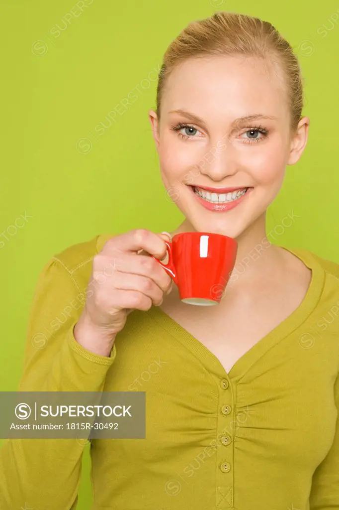 Young woman holding coffee cup, portrait