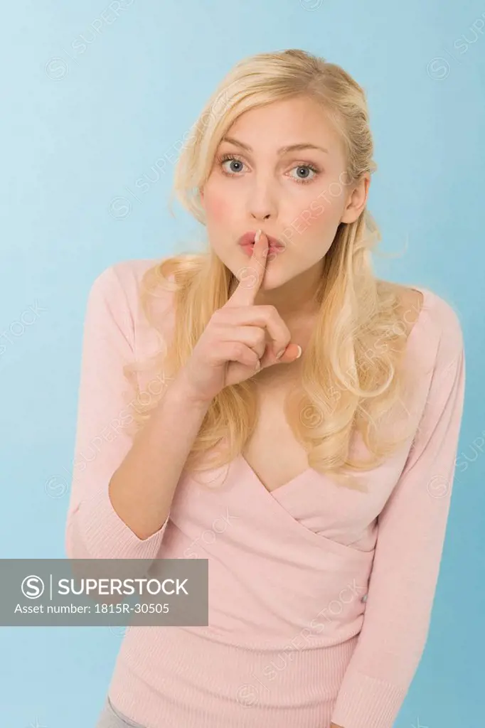 Young woman with finger on her lips, portrait