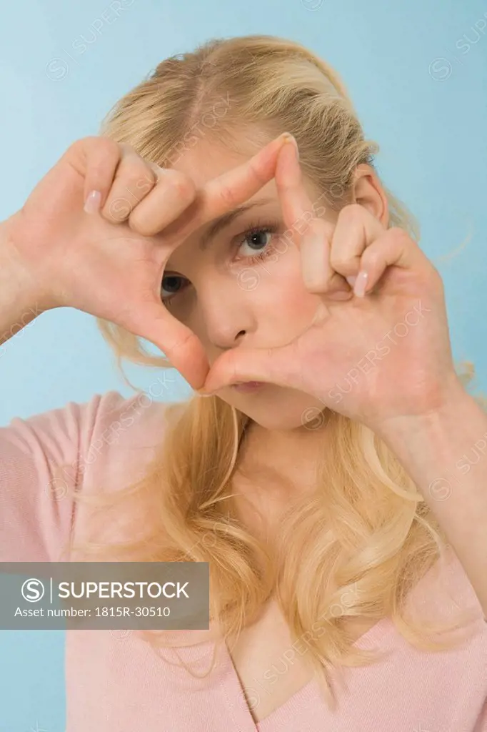 Blonde woman making hand gesture, portrait