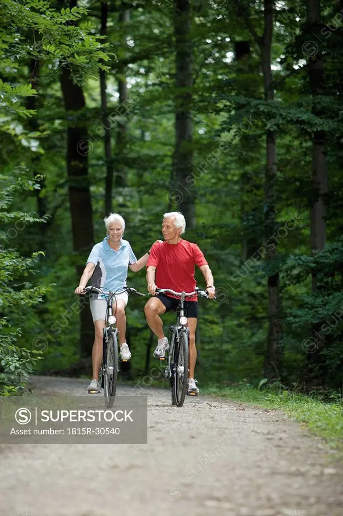 Senior couble biking on forest track