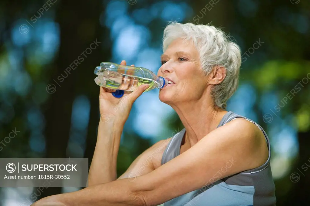 Senior woman, drinking from water bottle, portrait