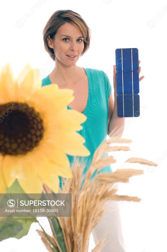 Woman holding solar cells, sunflower in foreground