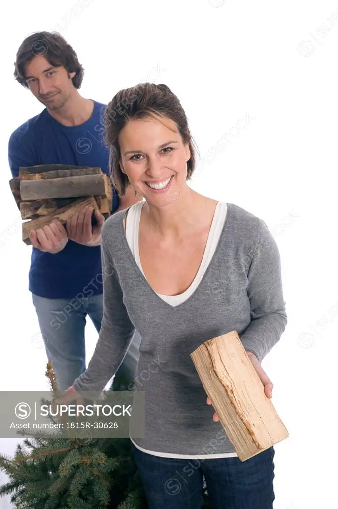 Couple with Christmas tree and firewood
