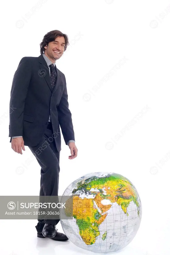 Businessman standing by globe