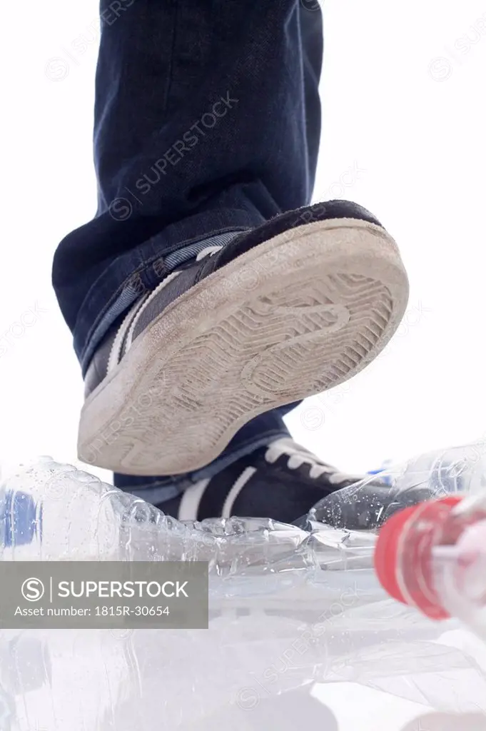 Man stepping on plastic bottles