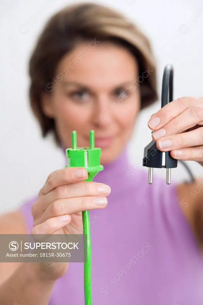 Woman holding green and black plugs