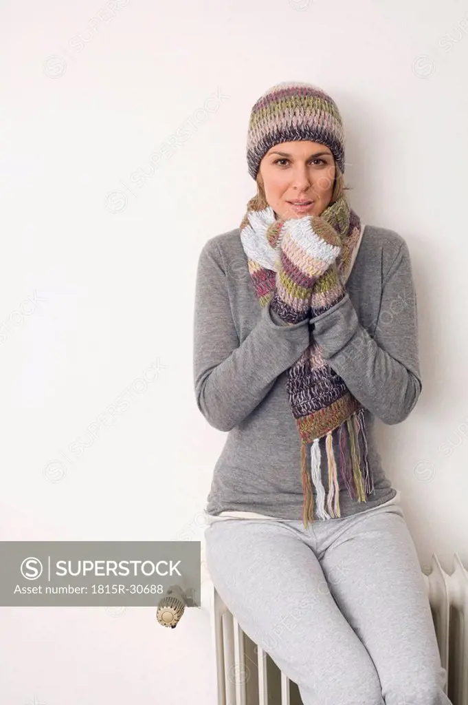 Woman leaning against heater, portrait