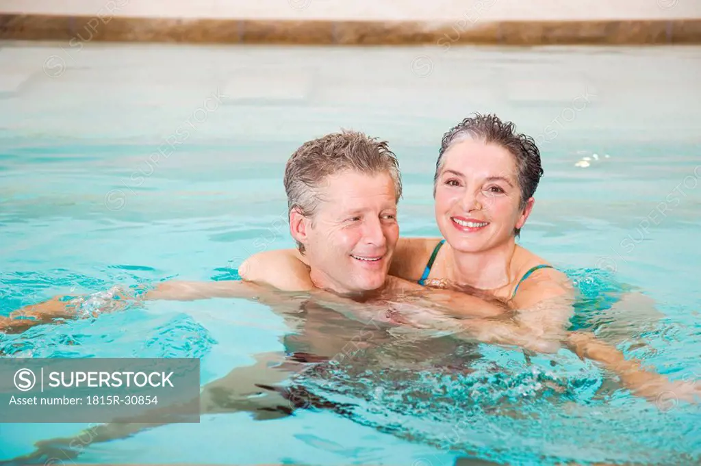 Mature couple embracing in swimmingpool, portrait