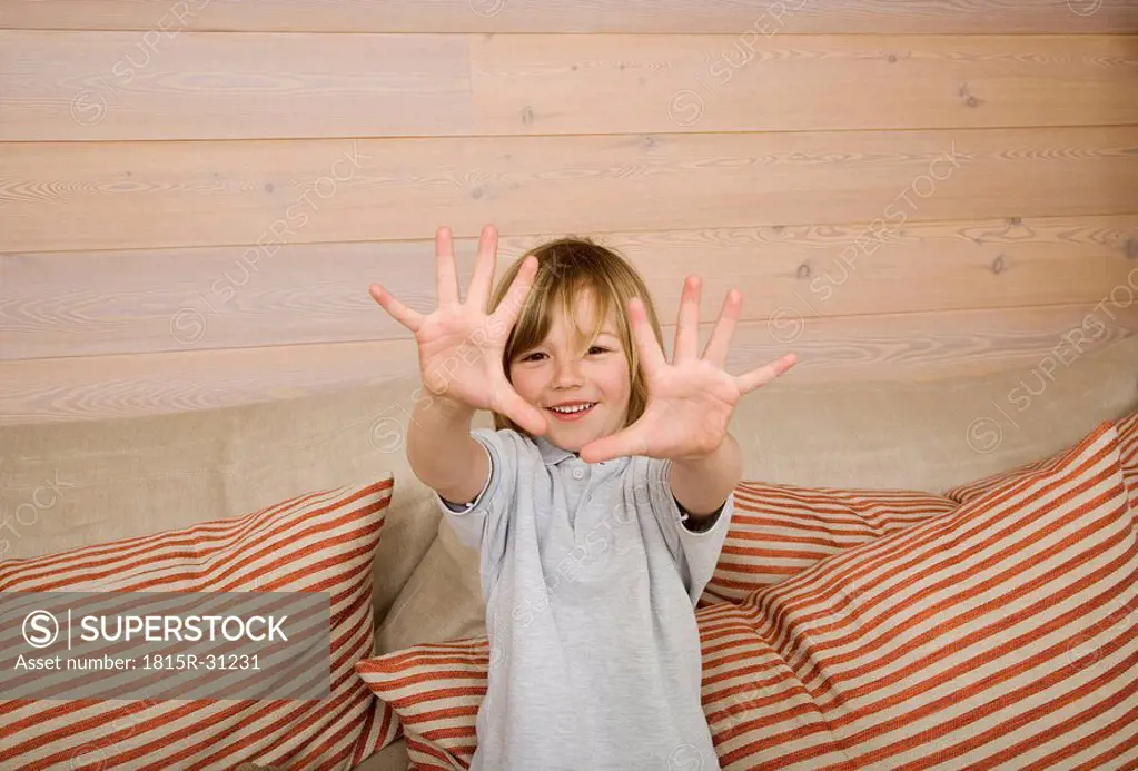Boy 8_9 showing all ten fingers at camera, smiling, portrait