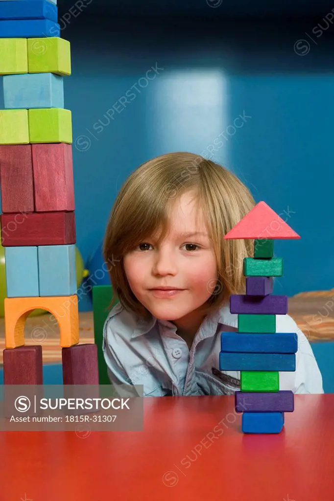 Boy 8_9 playing with building blocks, portrait