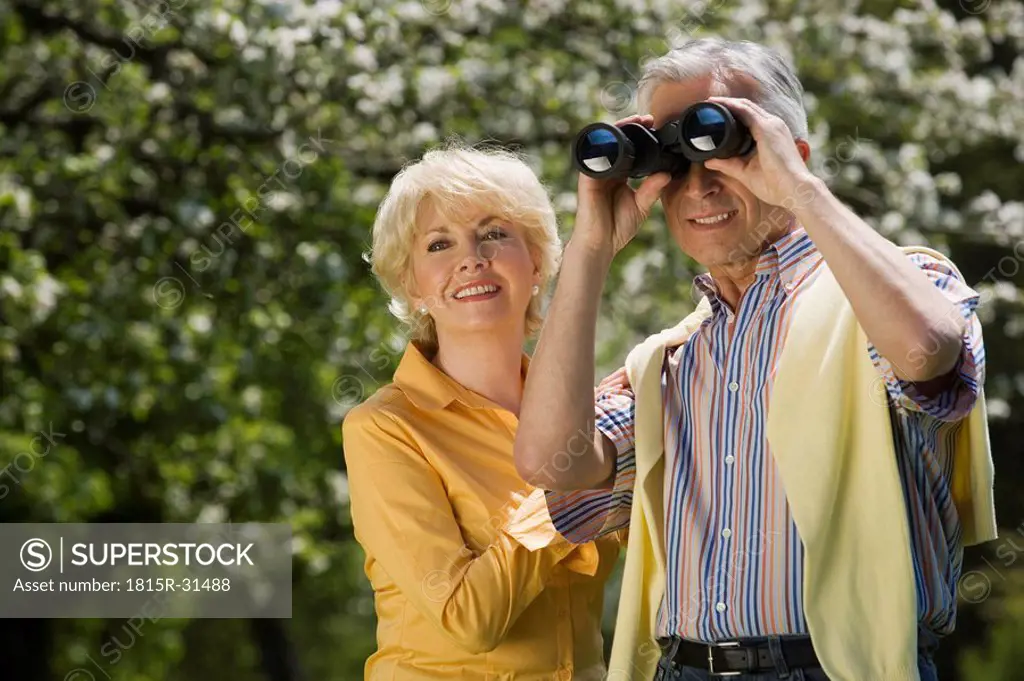 Germany, Baden Württemberg, Tübingen, Senior couple, senior man looking through binoculars