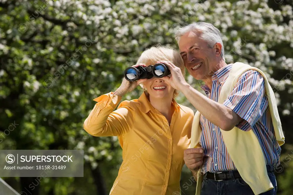 Germany, Baden Württemberg, Tübingen, Senior couple, senior woman looking through binoculars