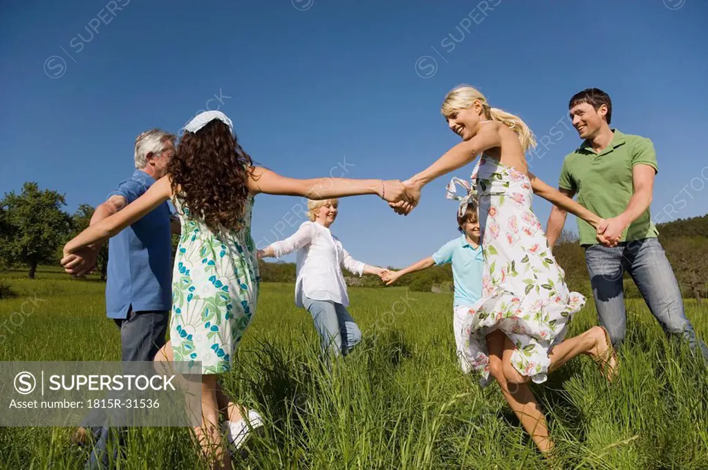 Germany, Baden Württemberg, Tübingen, Three generation family dancing in meadow