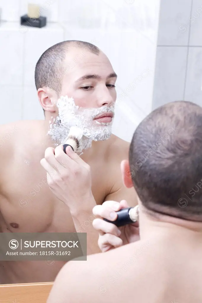 Man in bathroom, applying shaving foam, elevated view