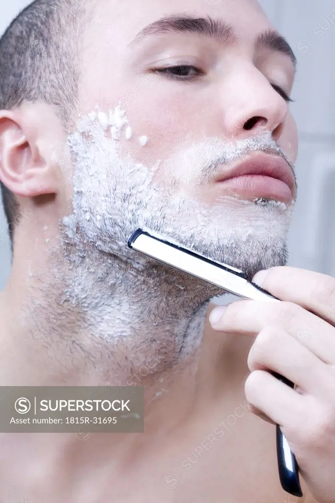 Man shaving with razor, close-up