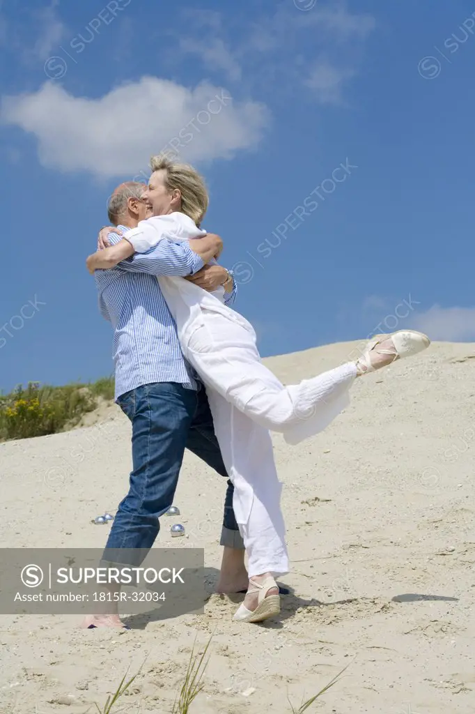 Mature couple playing boccia, embracing