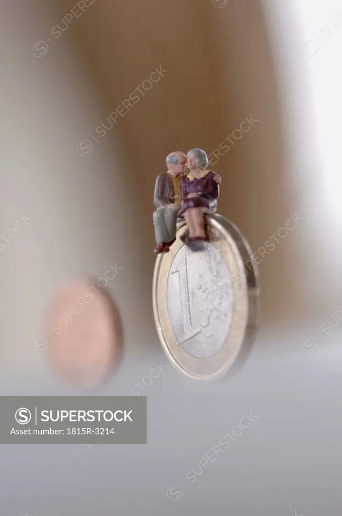 Senior couple sitting on coin, close-up