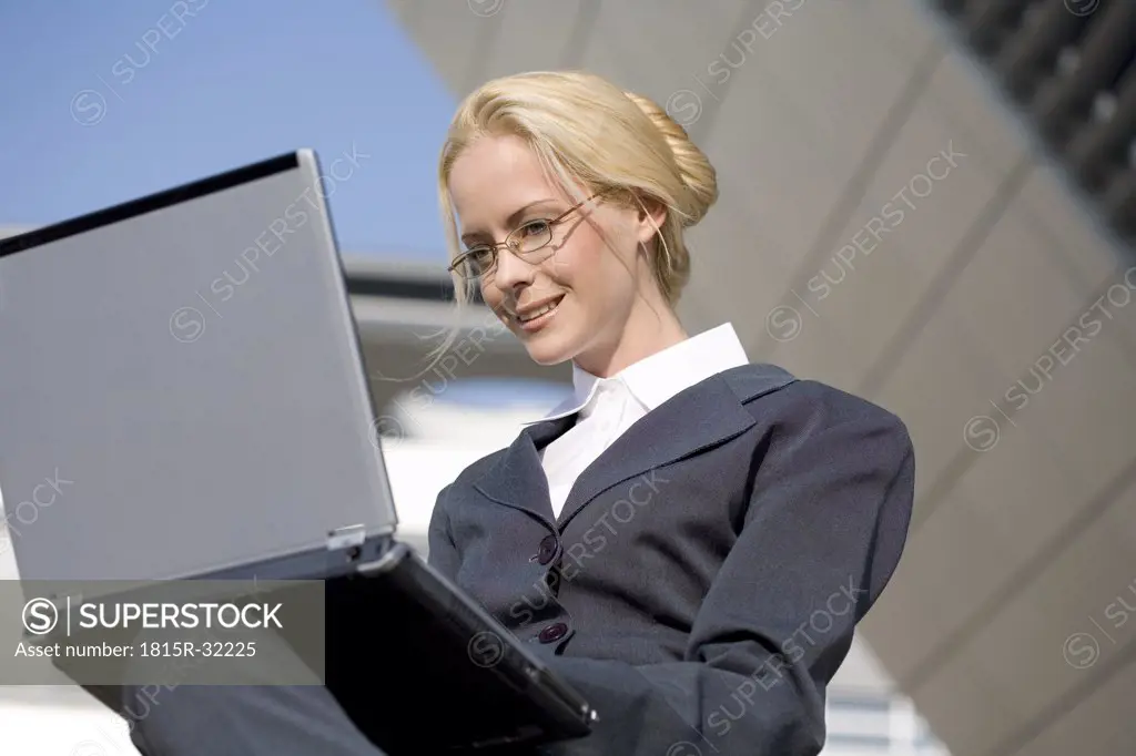 Business woman using laptop, portrait