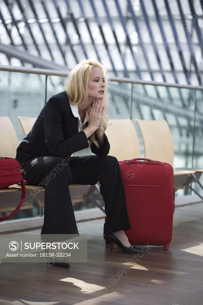 Business woman with luggage, waiting, portrait