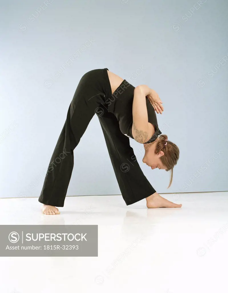 Young woman doing Yoga, performing ""Prasarita Padottanasana""