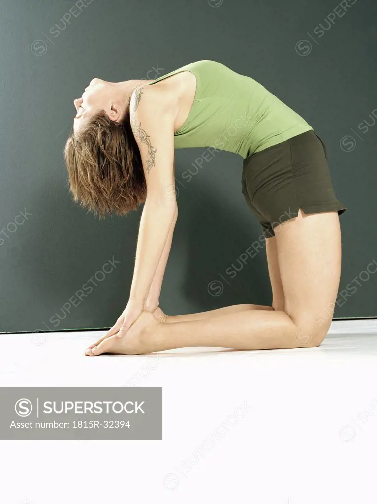 Young woman in ""camel"" yoga position