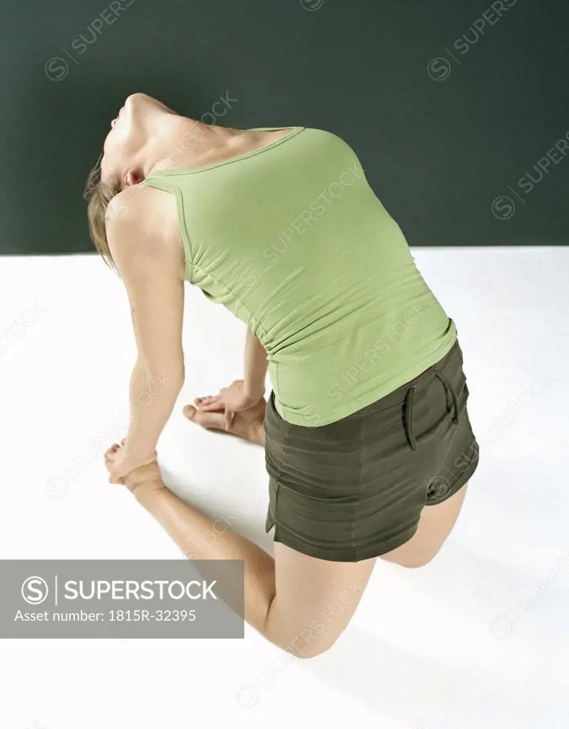 Young woman in ""camel"" yoga position, elevated view