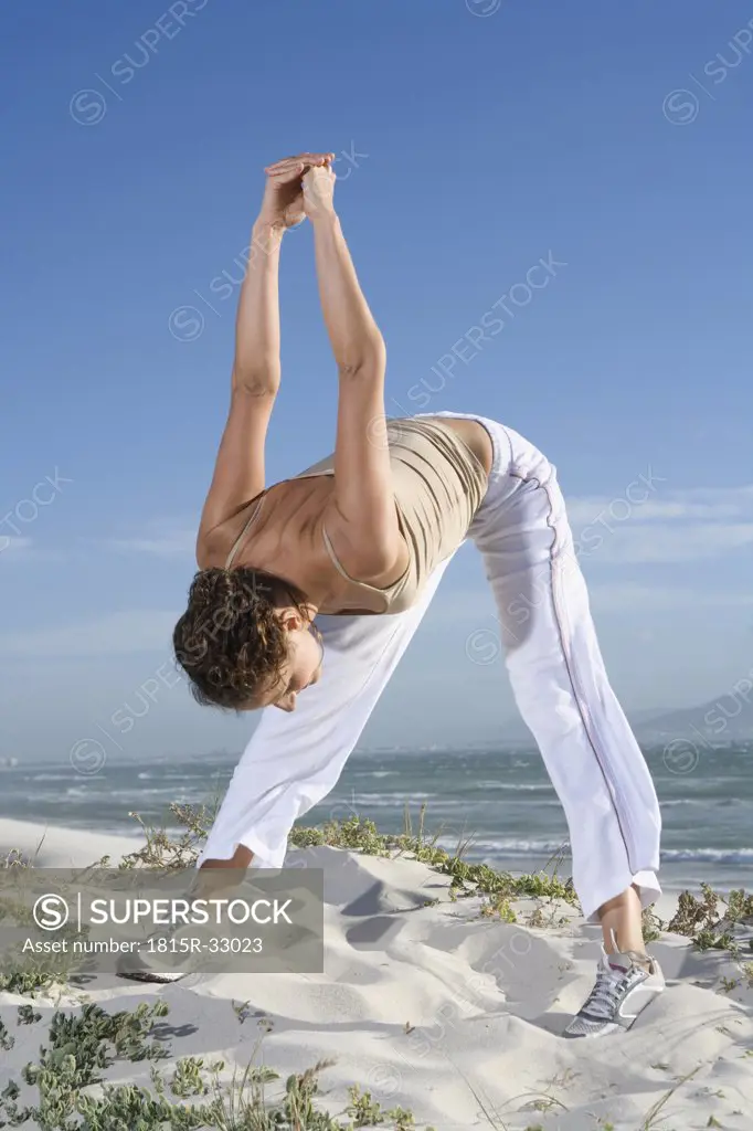 South Africa, Cape Town, Young woman exercising on beach