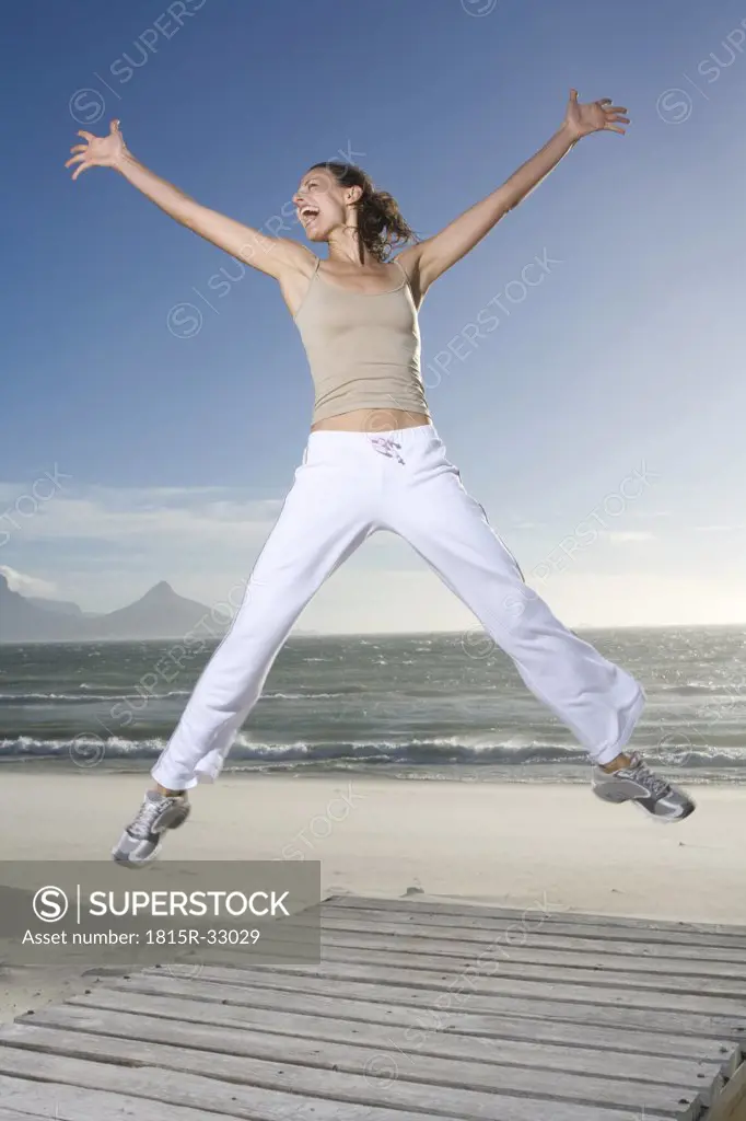 South Africa, Cape Town,Young woman jumping on beach