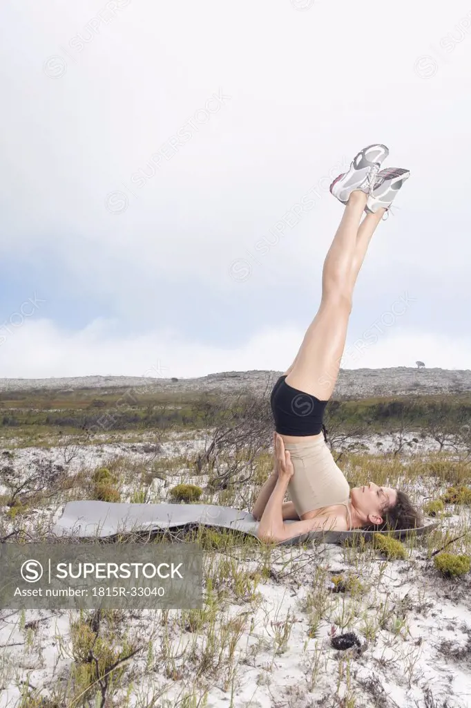 South Africa, Cape Town, Young woman practicing gymnastics, yoga position, candle move