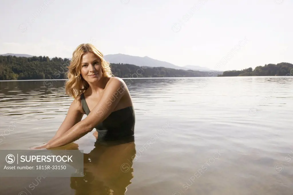 Woman sitting in lake, portrait