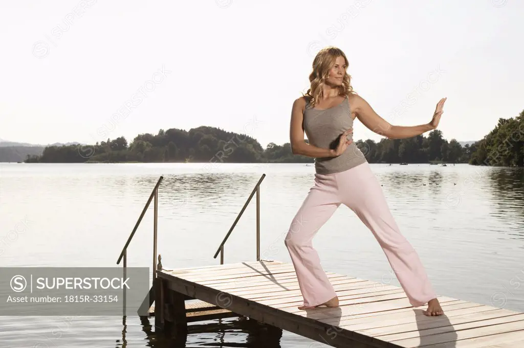 Woman exercising yoga on jetty