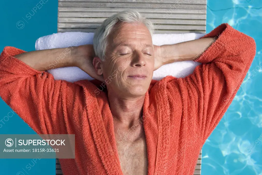 Germany, senior man relaxing on float in pool, close-up, portrait