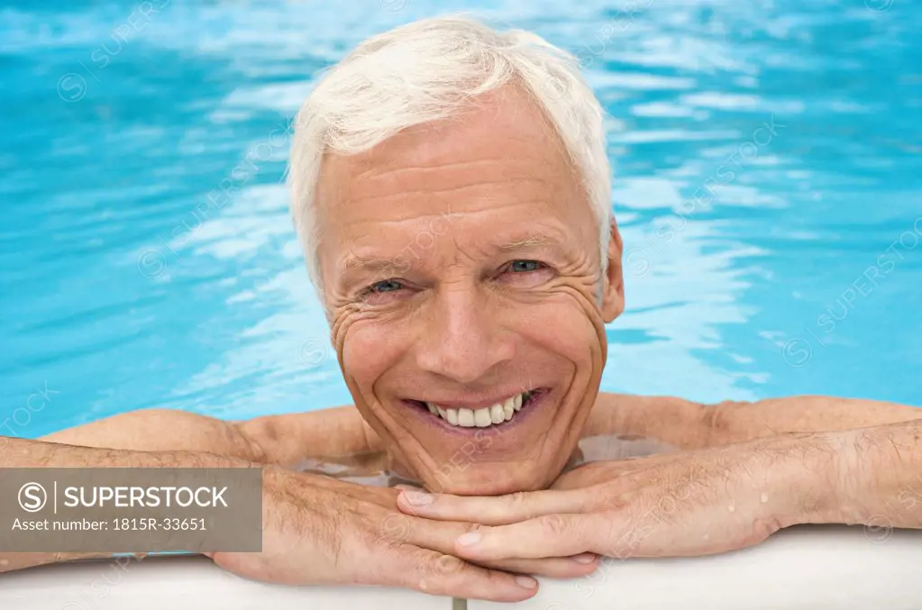 Germany, senior man relaxing in pool, close-up, portrait