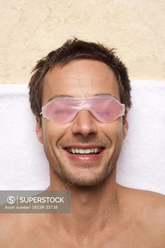 Germany, Man relaxing, wearing gel eye mask, close-up, portrait