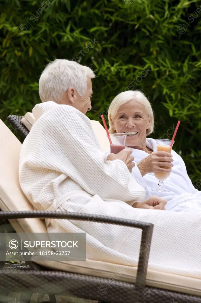 Germany, senior couple drinking smoothie in spa
