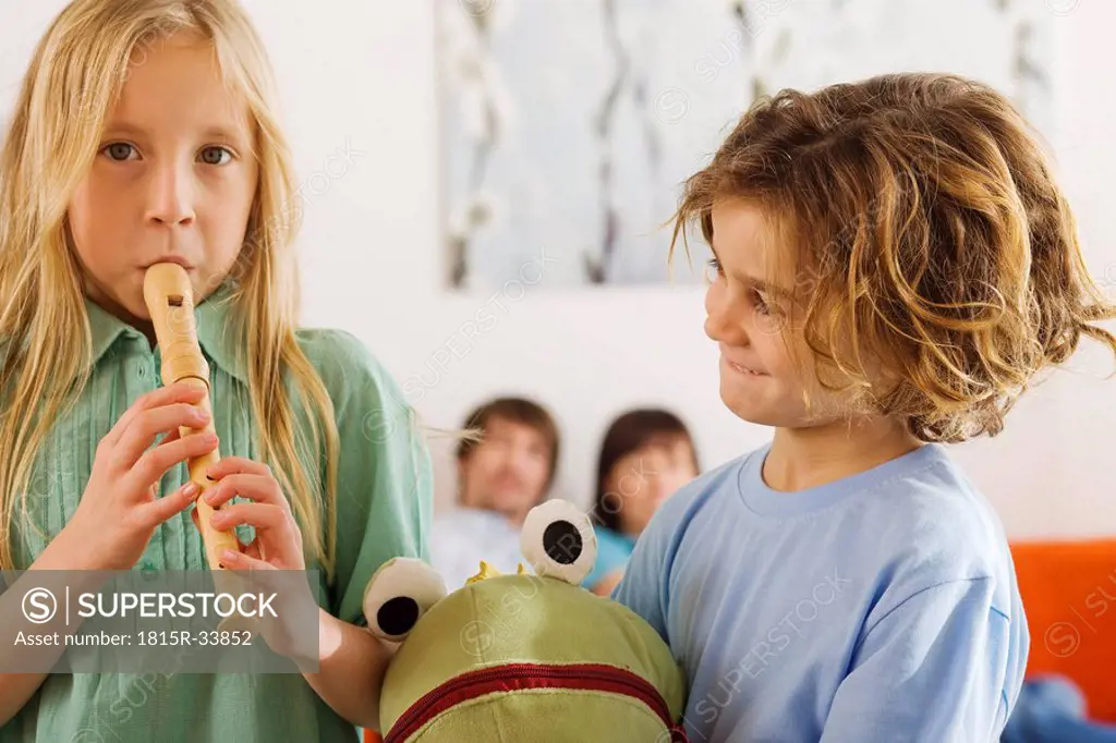 Boy 6_7 and girl 8_9, playing recorder, portrait