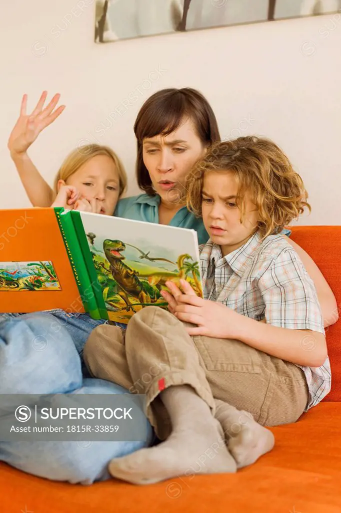 Mother reading story book to children