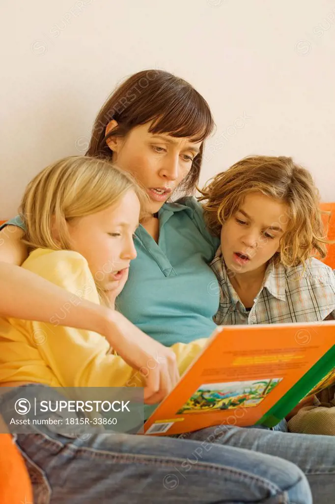 Mother reading story book to children