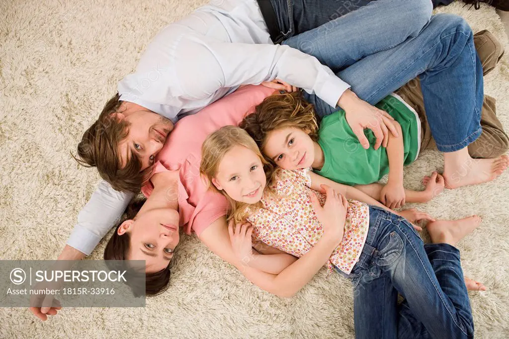 Family lying on floor in living room, elevated view