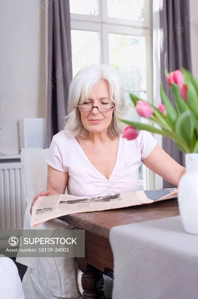 Senior woman reading newspaper, portrait