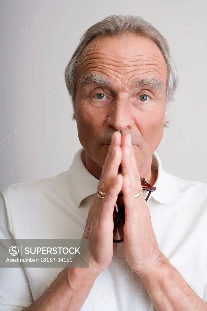 Senior man, folded hands, portrait