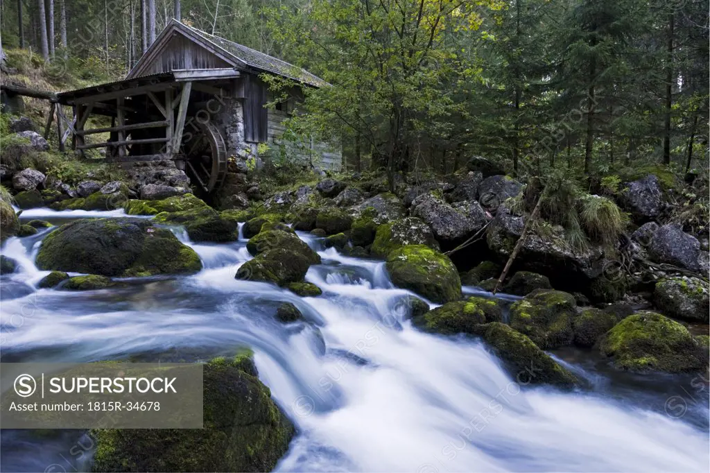 Austria, Golling, Waterfall overlooked by small wooden watermill.