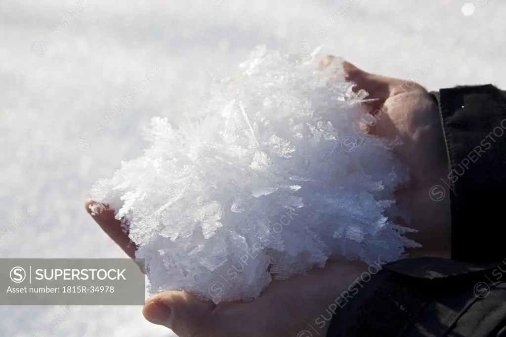 Germany, Bavaria, Hands holding ice crystals, close-up