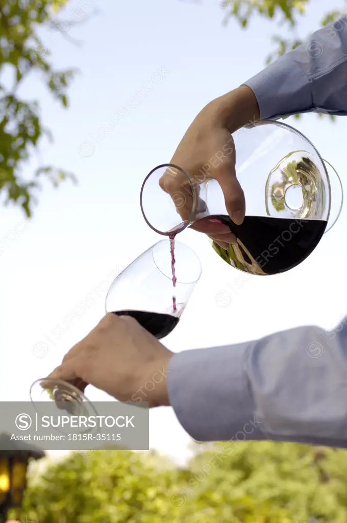 Man pouring red wine in glass
