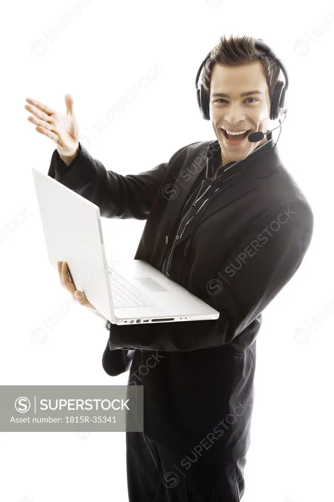 Young man wearing headphones, holding laptop,close-up