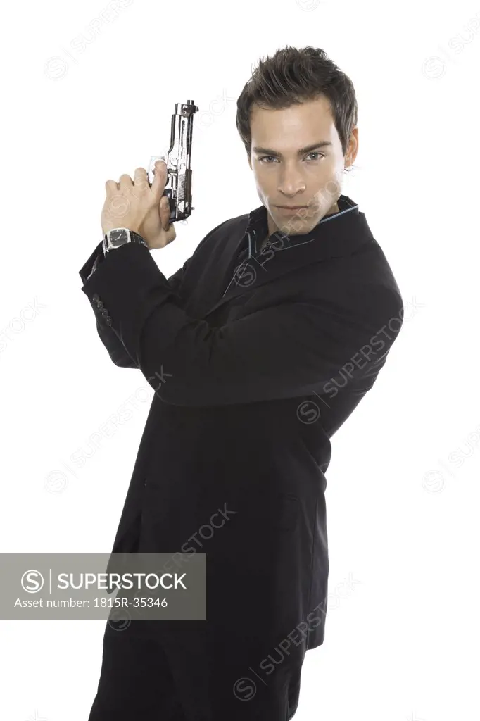 Young man holding hand gun, close-up