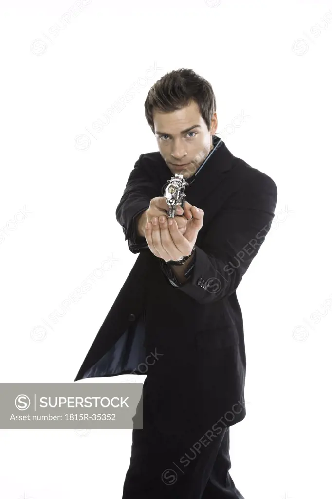 Young man holding hand gun, close-up