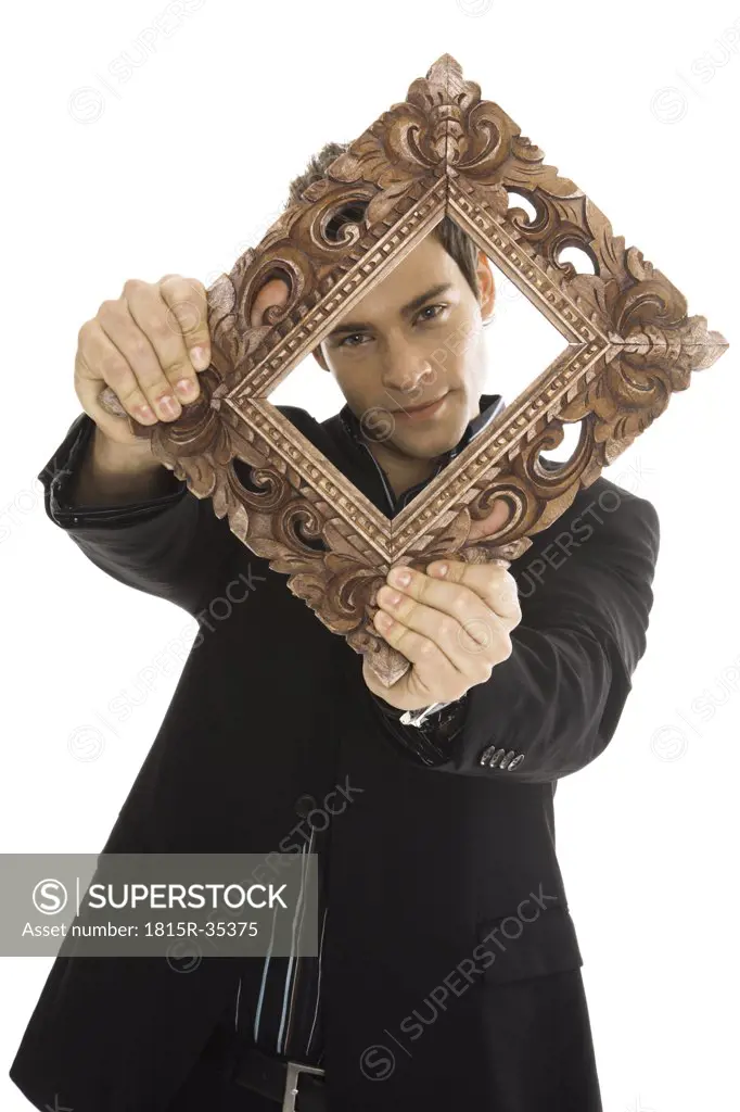 Young man holding picture frame, close-up