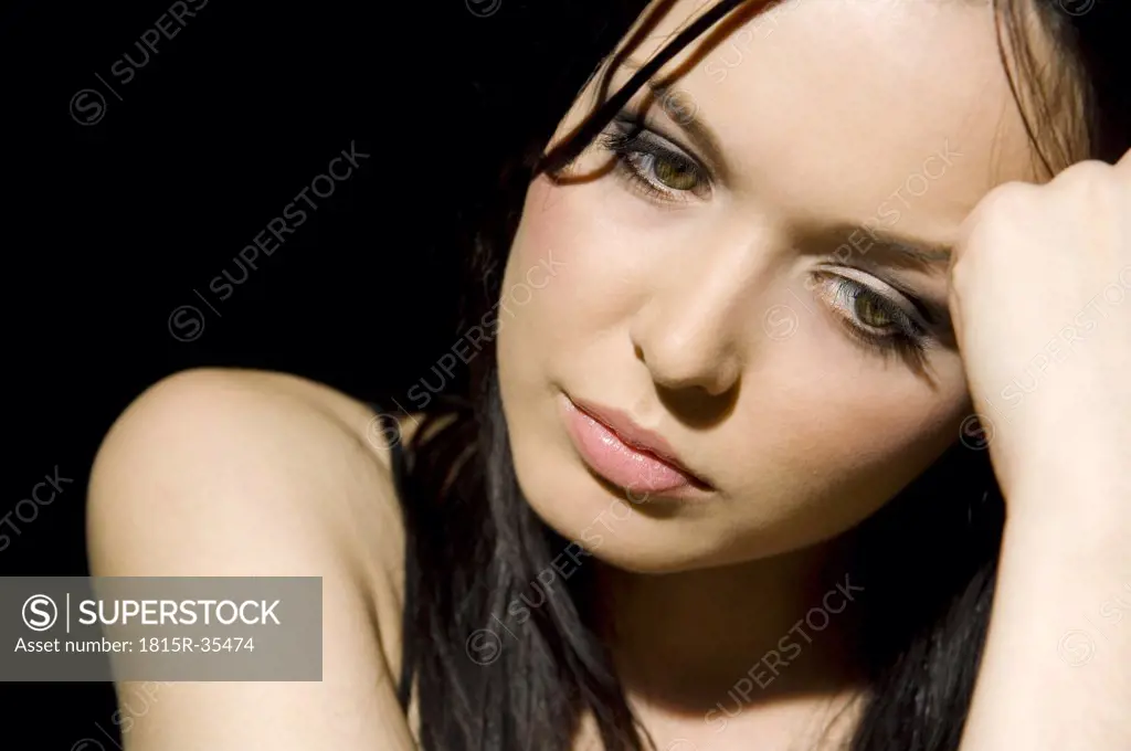 Dark-haired woman hand to head