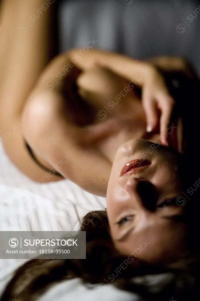Naked woman lying in bed